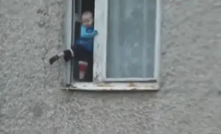 Малыш веселится на окне седьмого этажа